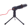 Black wired PC microphone with attached metal clip holder on a desk.