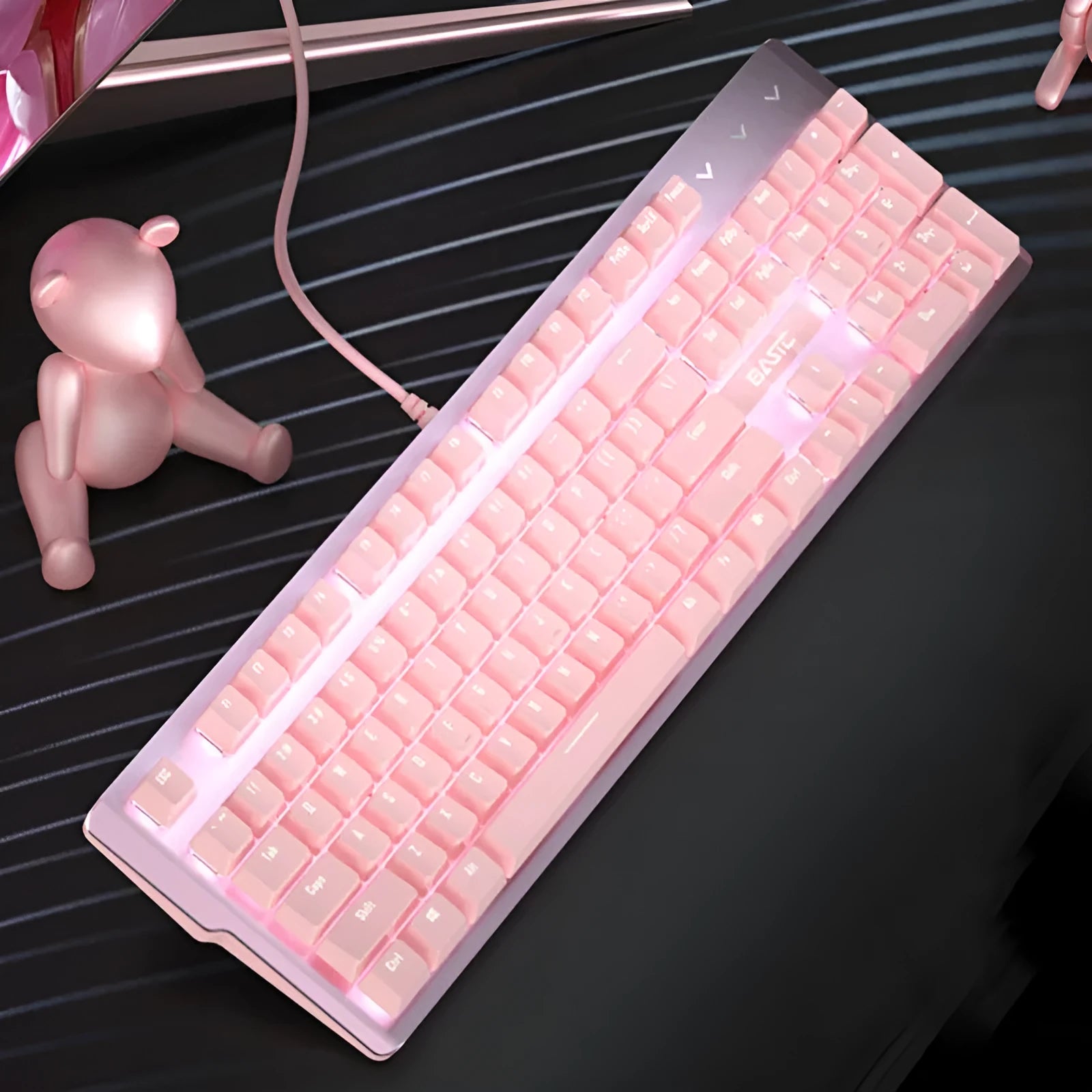 Pink wired mechanical keyboard and matching mouse for PC gaming on a desk.