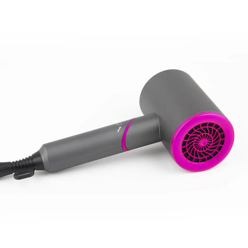Foldable hair dryer in dark green with gold trim, showing concentrator nozzle and diffuser attachment.