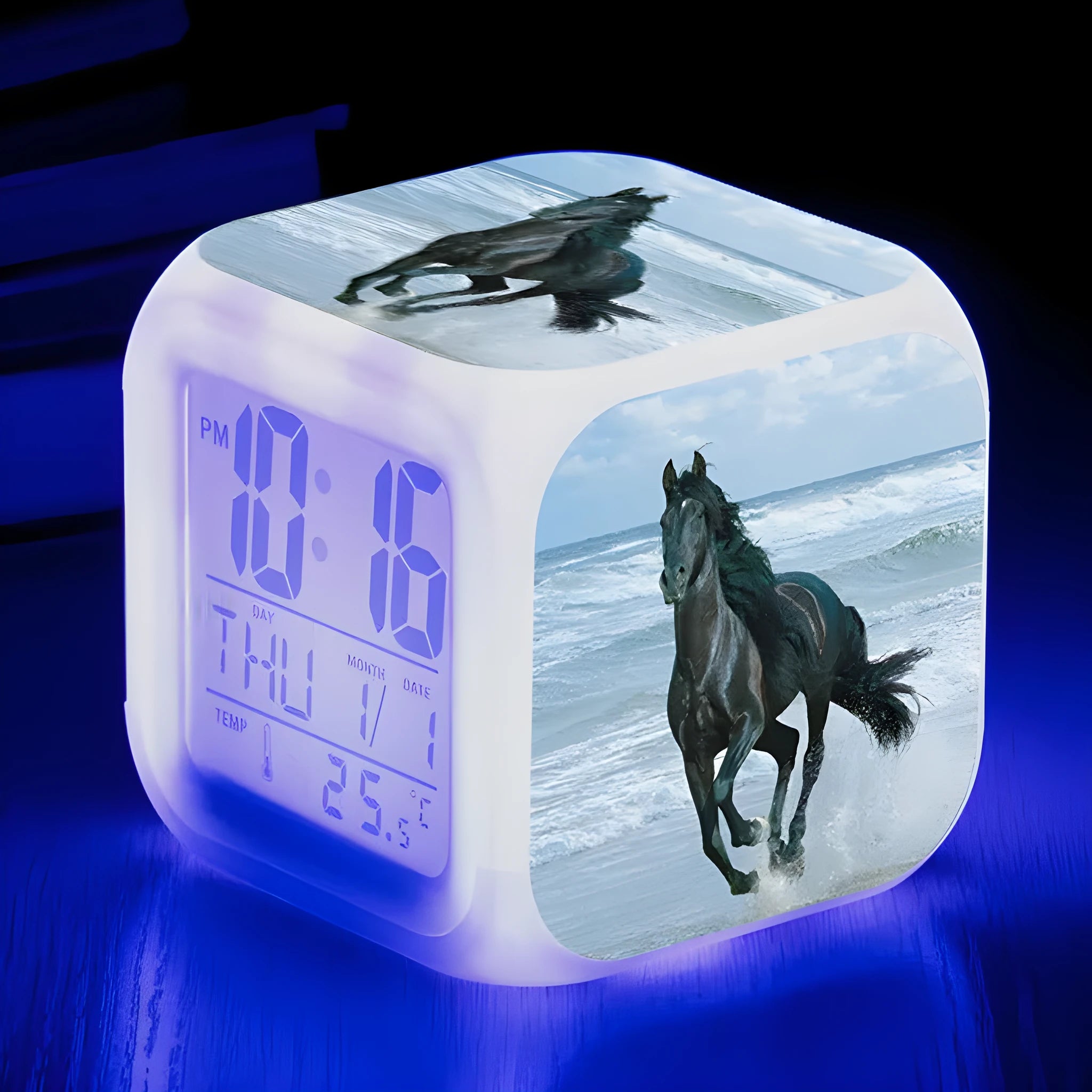 Square cartoon-style alarm clock with digital LED display showing time, placed on a wooden surface.