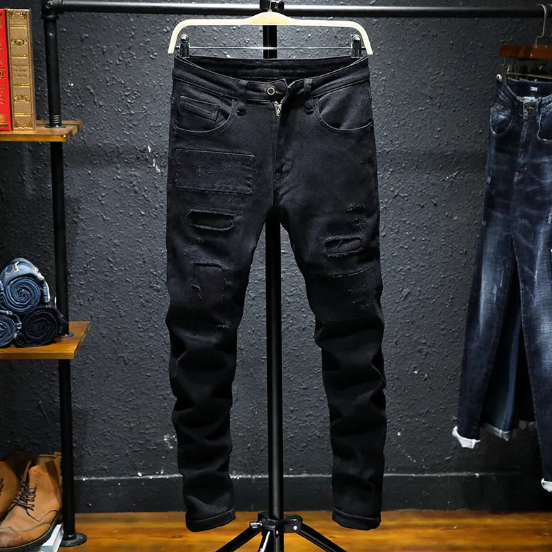 Men's black ripped stretch jeans with straight leg, distressed hand-painted details, and zipper front, shown on model.