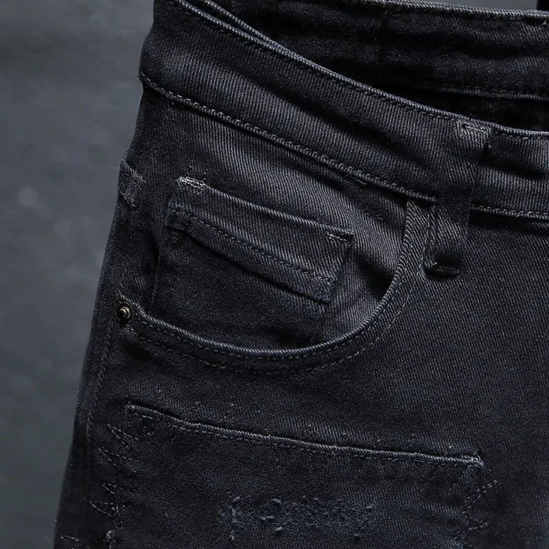 Men's black ripped stretch jeans with straight leg, distressed hand-painted details, and zipper front, shown on model.