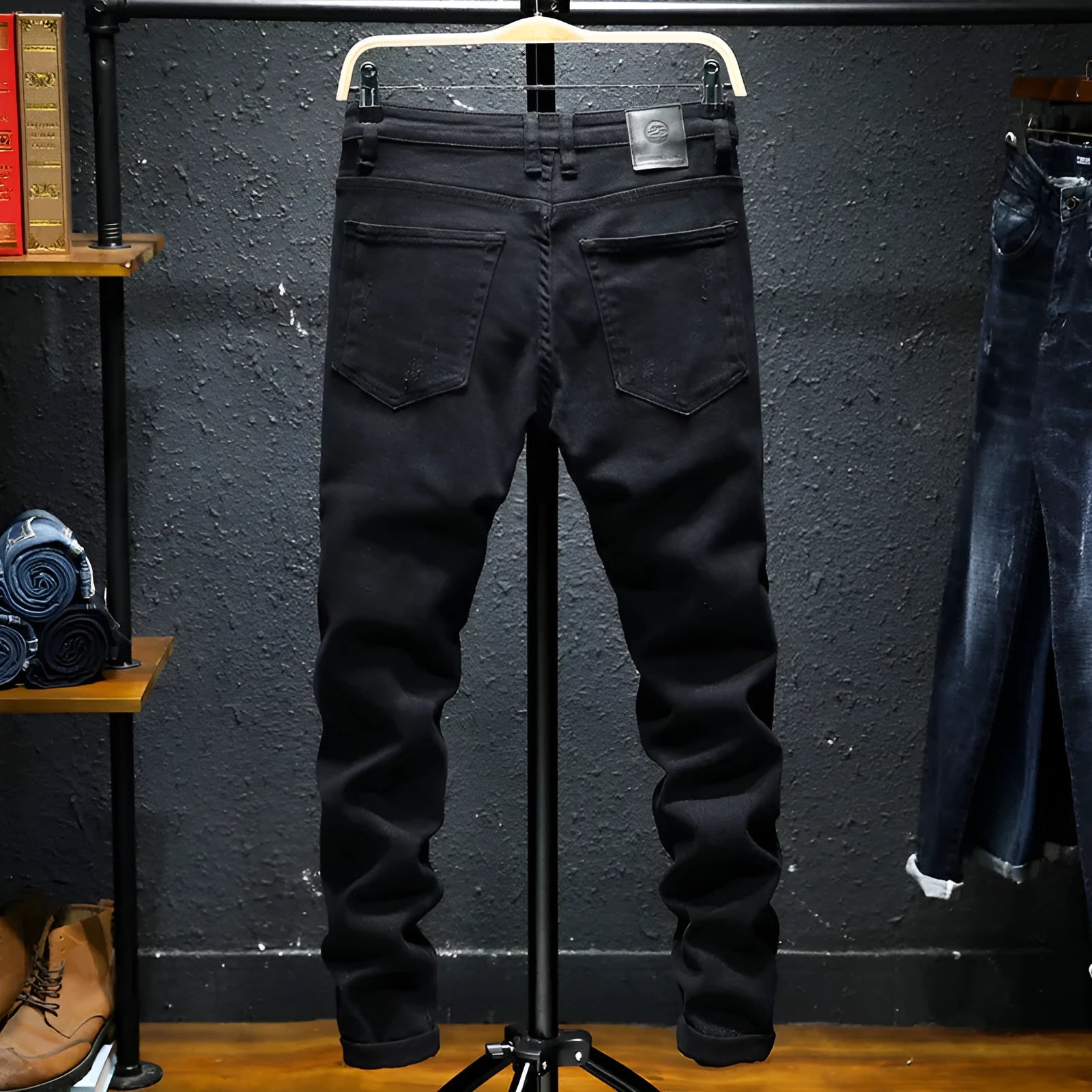 Men's black ripped stretch jeans with straight leg, distressed hand-painted details, and zipper front, shown on model.