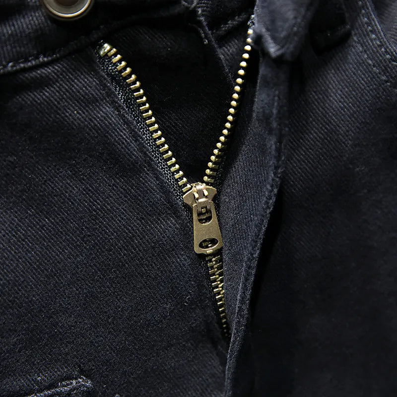 Men's black ripped stretch jeans with straight leg, distressed hand-painted details, and zipper front, shown on model.