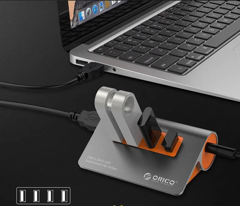 Dark grey and orange aluminium USB-C hub with four USB ports, a blue LED light, and a separate data cable.