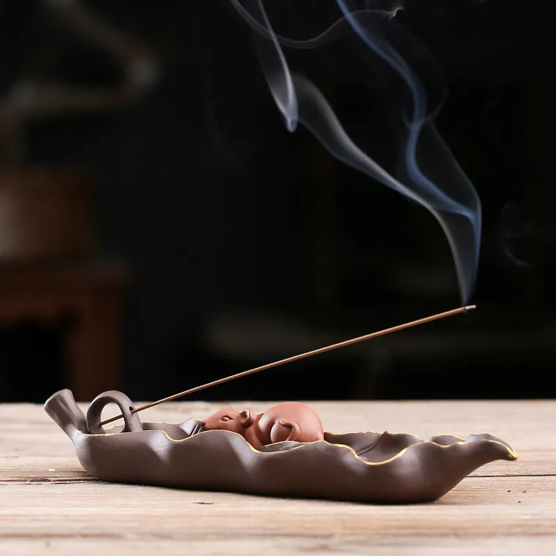 Purple clay ceramic lying incense burner with golden rat design holds incense stick