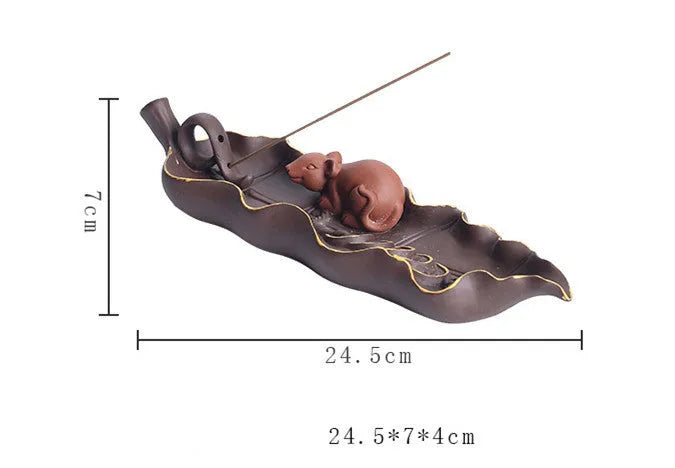 Purple clay ceramic lying incense burner with golden rat design holds incense stick