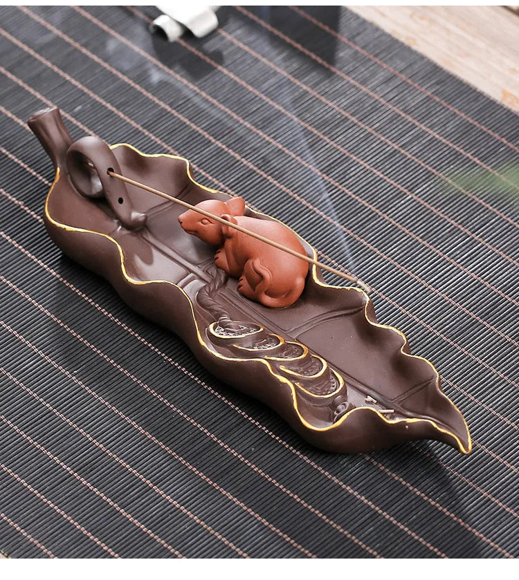 Purple clay ceramic lying incense burner with golden rat design holds incense stick