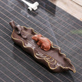 Purple clay ceramic lying incense burner with golden rat design holds incense stick