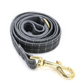 Grey plaid nylon dog collar with golden metal button on a white background, size M shown