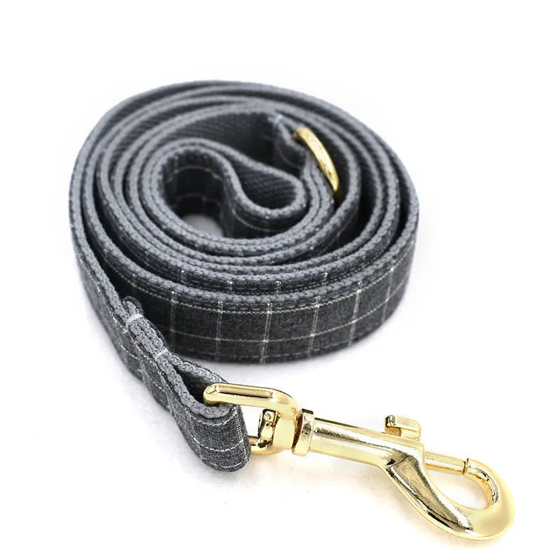 Grey plaid nylon dog collar with golden metal button on a white background, size M shown