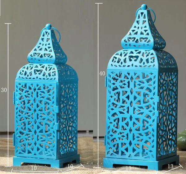 A blue iron candelabro with geometric hollow design, standing 38 cm tall on a table.