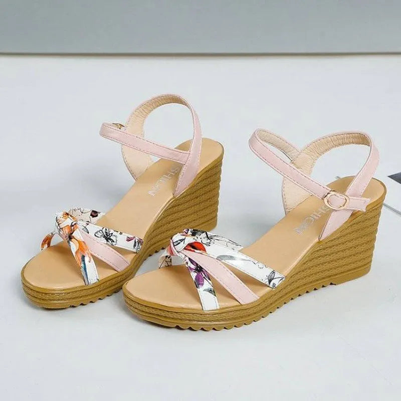 Pink and white women's wedge sandals with a buckle and non-slip platform sole.
