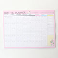 Domikee pink and green paper desk organiser planner notebook open on a desk.