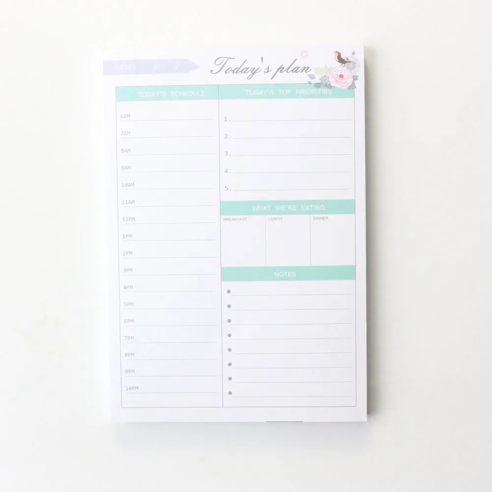 Domikee pink and green paper desk organiser planner notebook open on a desk.