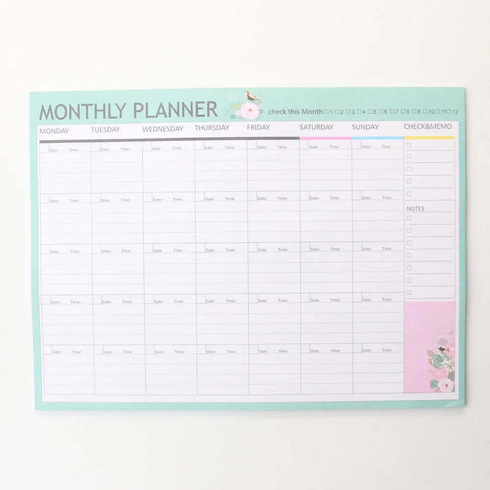 Domikee pink and green paper desk organiser planner notebook open on a desk.