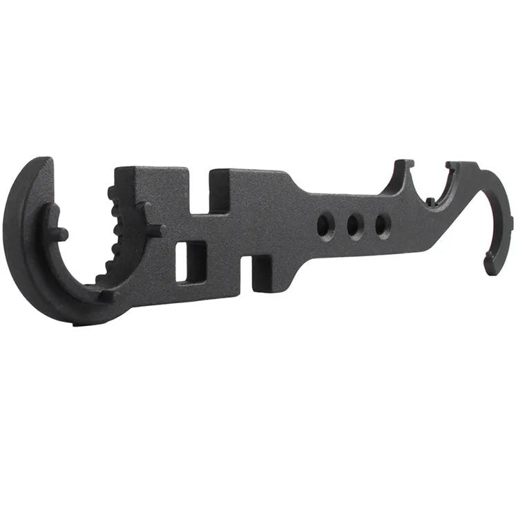 Black all-steel dual-purpose combination wrench for AR-15 and M4 rifle maintenance on a workshop bench.