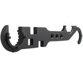 Black all-steel dual-purpose combination wrench for AR-15 and M4 rifle maintenance on a workshop bench.