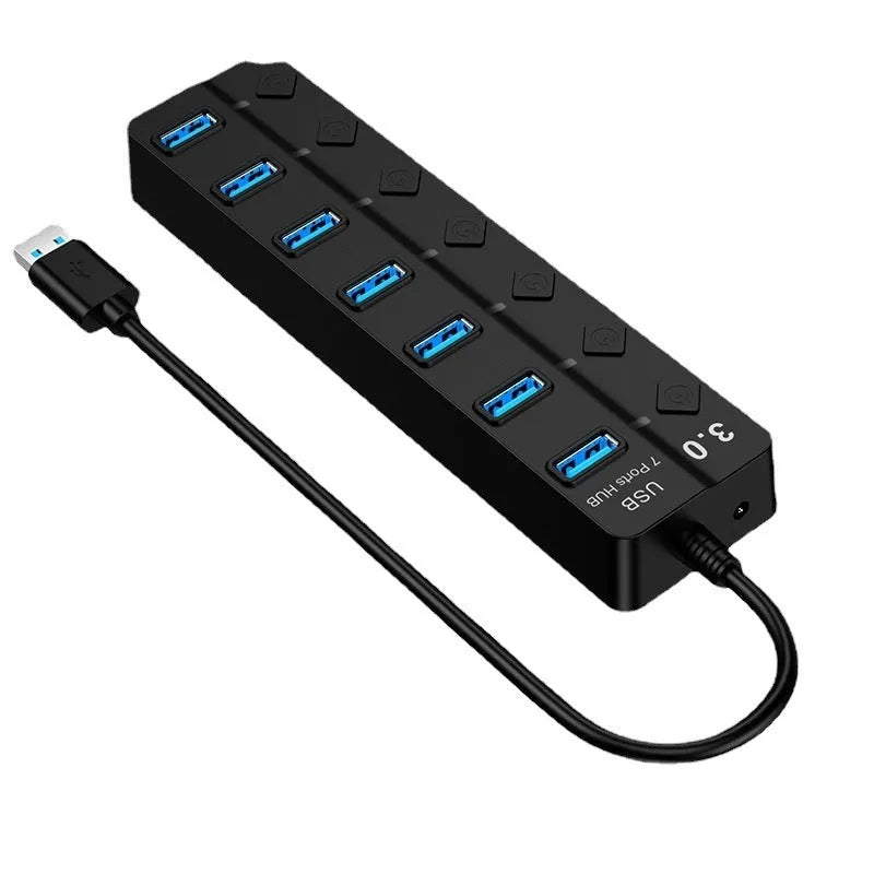 Black 7-port USB 3.0 hub with external power supply on a desktop.