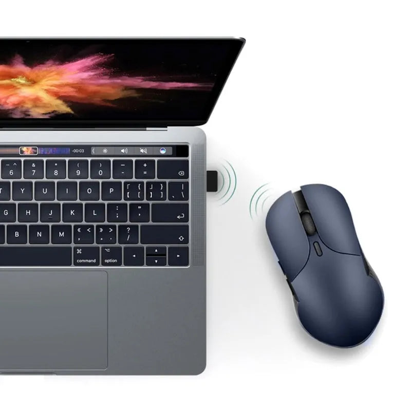 Blue rechargeable wireless voice translator mouse on a desk next to a laptop.