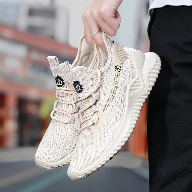 Men's white low-top mesh sports trainers with rubber sole and round toe on a plain background