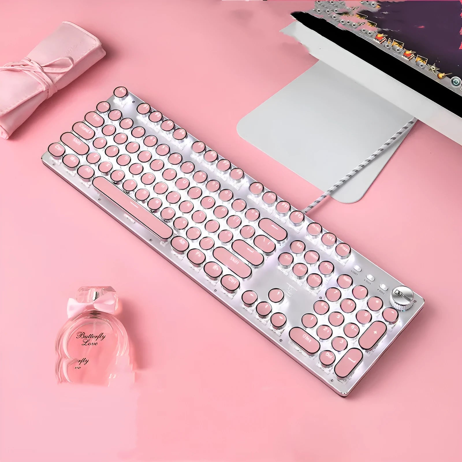 Pink and silver wired mechanical keyboard with green switches and matching mouse on a desk.