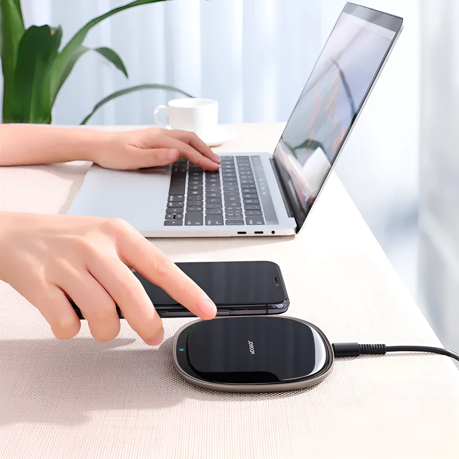 Black circular 15W wireless charging pad with a glass top and zinc alloy rim on a desk.
