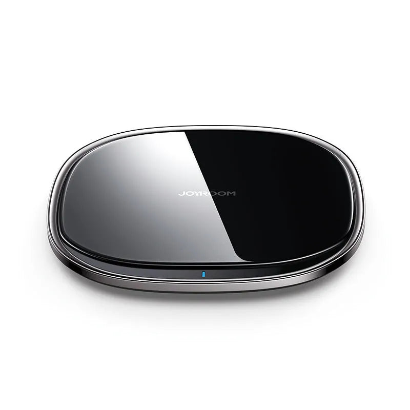 Black circular 15W wireless charging pad with a glass top and zinc alloy rim on a desk.