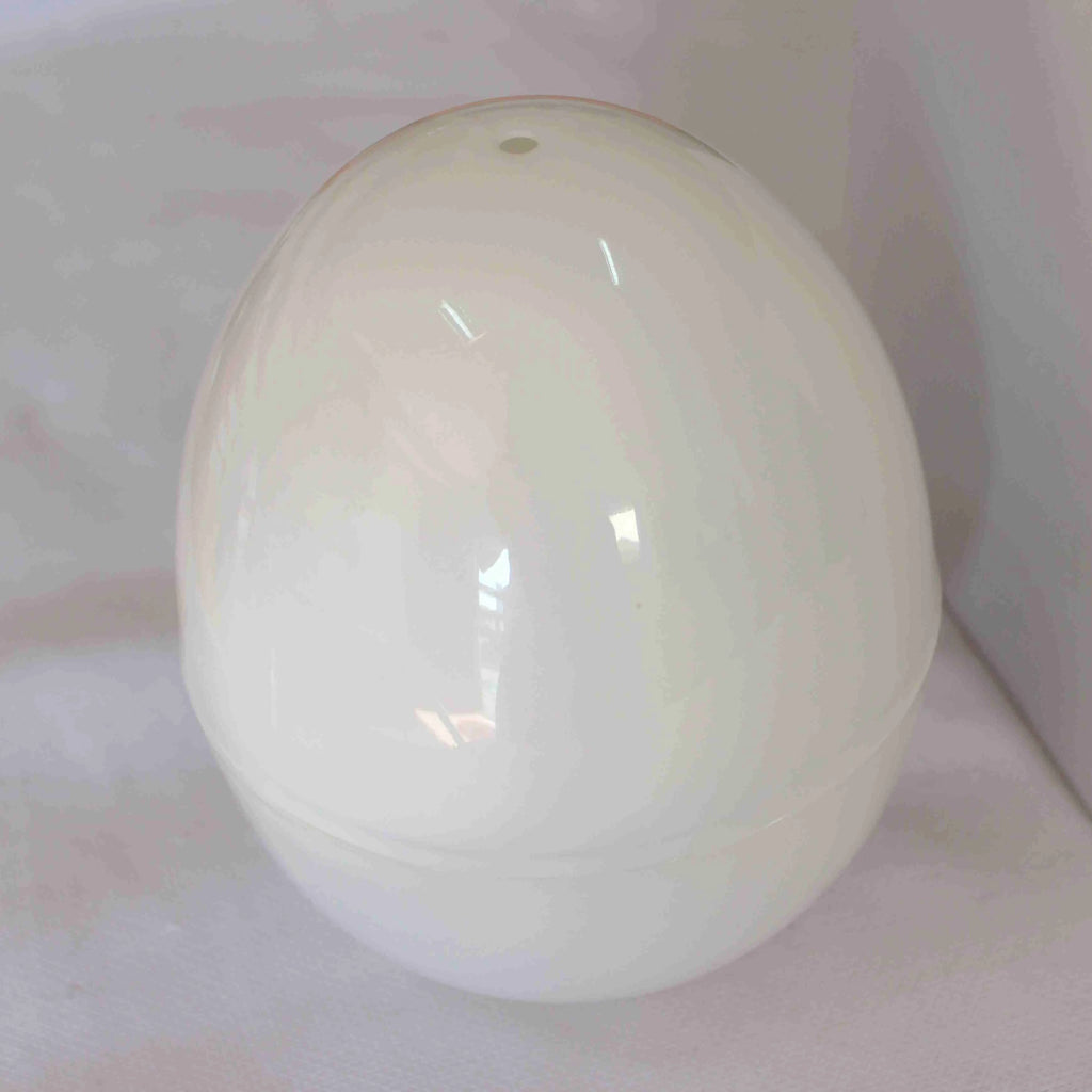 White egg-shaped microwave cooker for boiling up to four eggs, showing vent hole and knob.