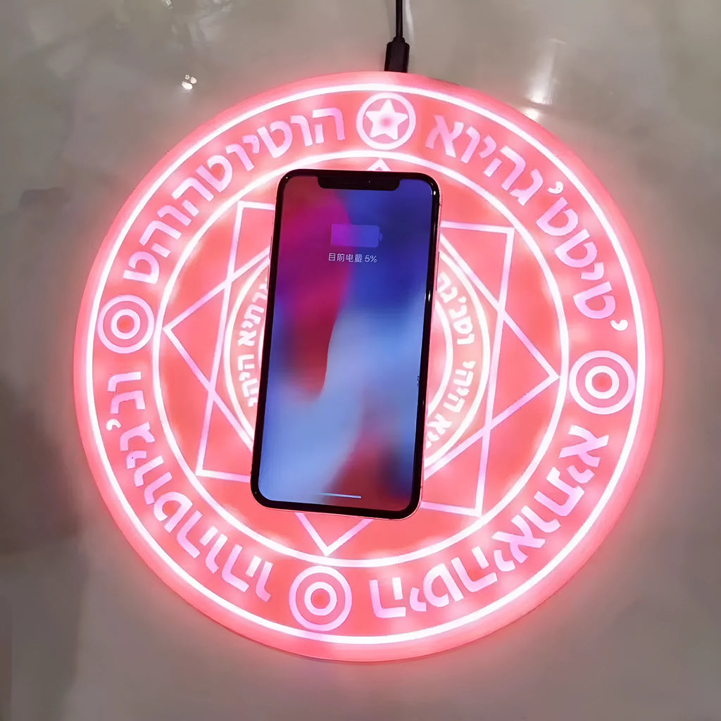Square black wireless charging pad with glowing magic array pattern, charging a mobile phone.