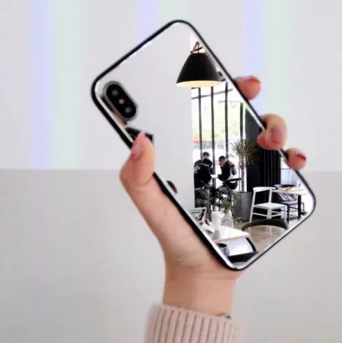 Black iPhone phone case with a built-in circular mirror on the back, shown next to an iPhone.