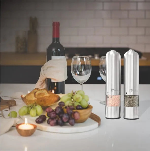 Tall stainless steel electric pepper grinder on a kitchen countertop.