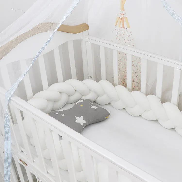 Baby crib bumper protector in spandex velvet, bent to show flexible shape, against a crib rail.