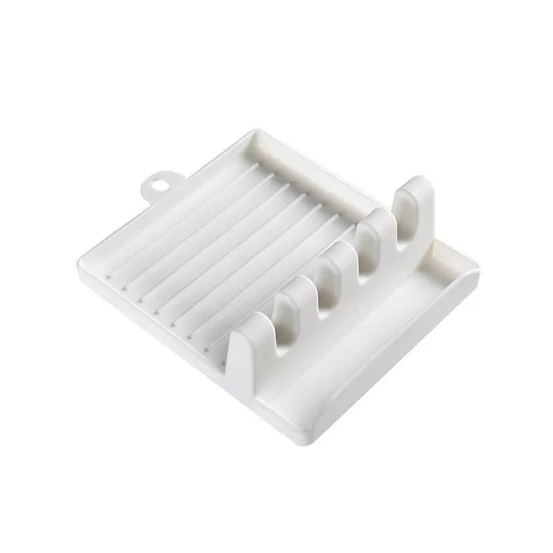 Green silicone kitchen utensil holder with four holes holding spatula, spoon, knife, and chopsticks on countertop