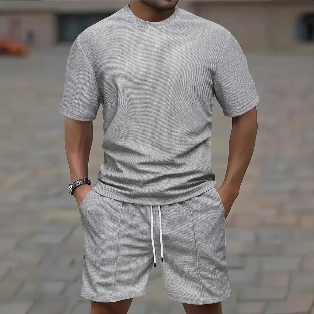 Man wearing a light waffle-texture short sleeve blouse and matching shorts in apricot colour.