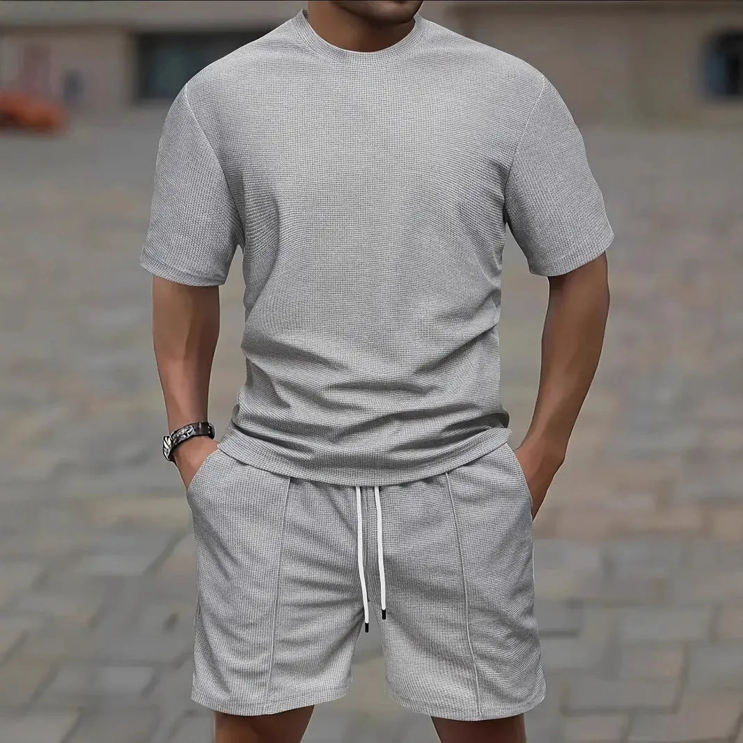 Man wearing a light waffle-texture short sleeve blouse and matching shorts in apricot colour.