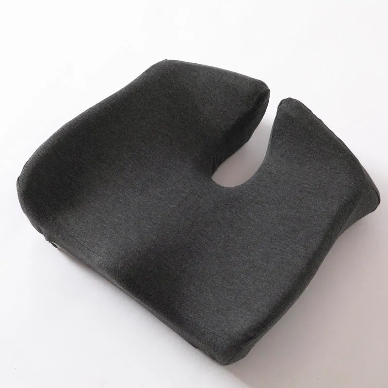 Black memory foam office chair cushion for waist support, shown on a desk chair.