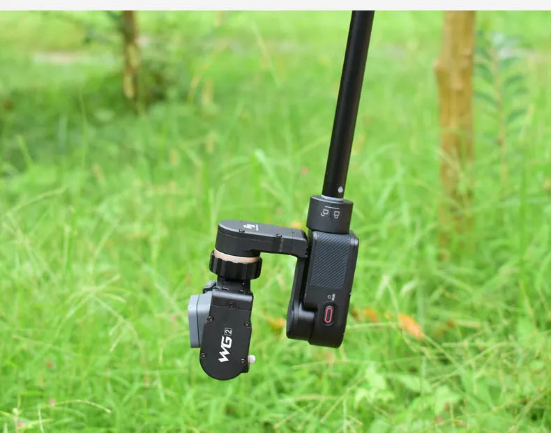 Black retractable aluminium selfie stick extended with a phone attached, showing its handheld stabiliser grip.