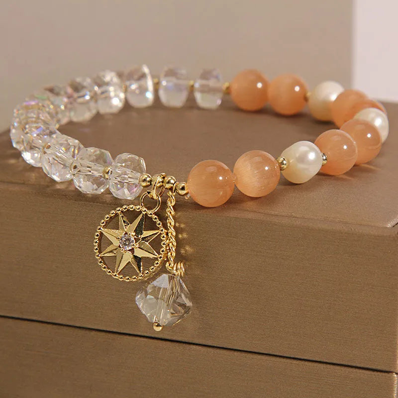 Gold-plated women's bracelet with an eight Awn star design and an orange crystal inlay.
