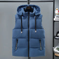 Man wearing a solid blue thickened vest with a removable hood and slant pockets.