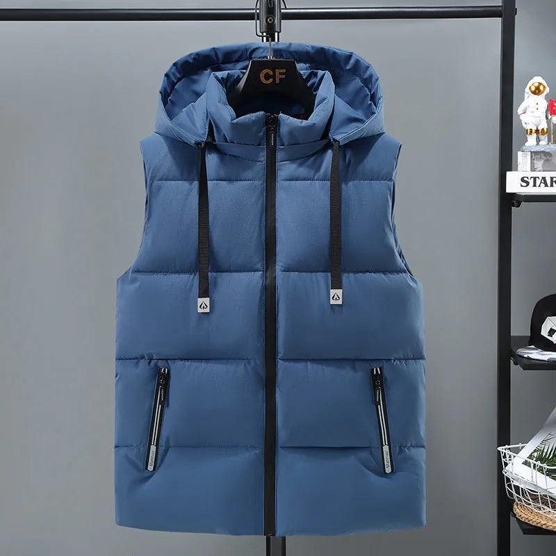 Man wearing a solid blue thickened vest with a removable hood and slant pockets.