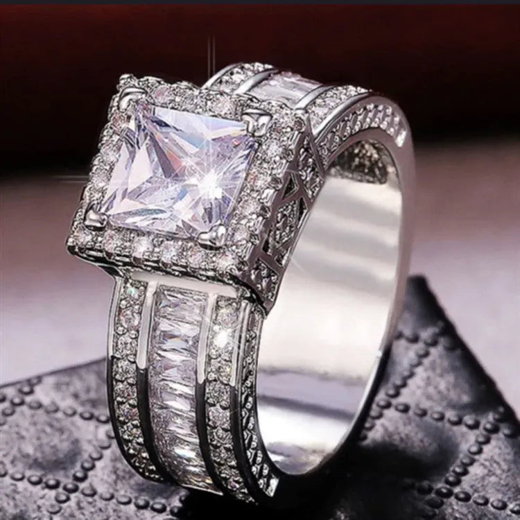 Geometric silver fashion ring for women in gold or white colour on a grey background.