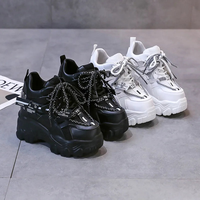 Women's white and black platform tennis shoes with mesh upper and cross-strap.