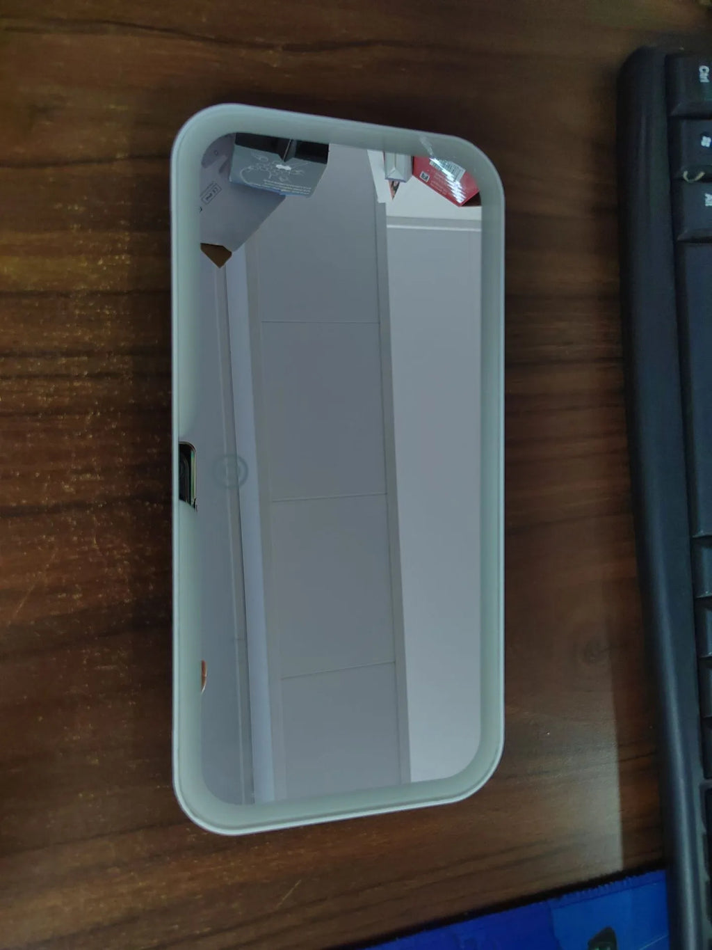 White car sun visor with rectangular LED-lit make-up mirror mounted on it.