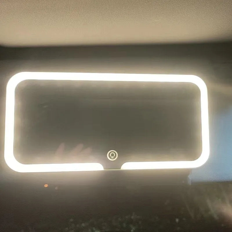 White car sun visor with rectangular LED-lit make-up mirror mounted on it.
