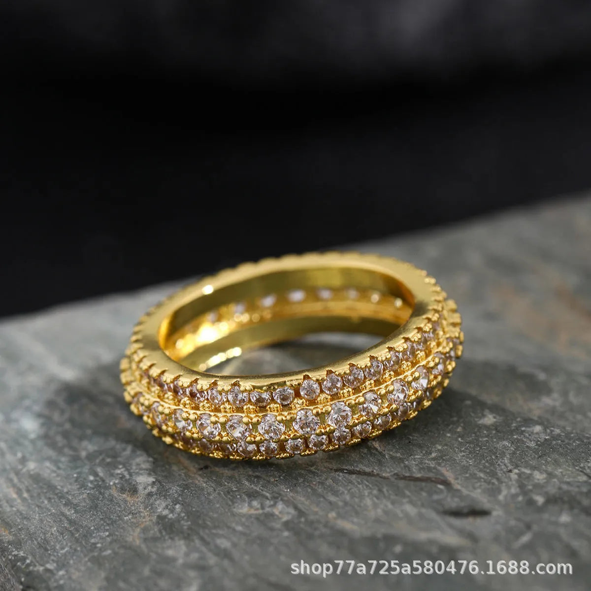 A geometric triangle-shaped ring with a zircon stone inlay, shown in a choice of metal colour finishes.