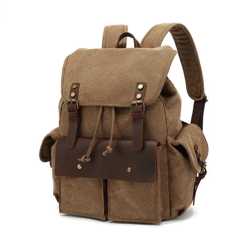 Retro canvas backpack in khaki colour with antique bronze hardware, showing front compartments and straps.