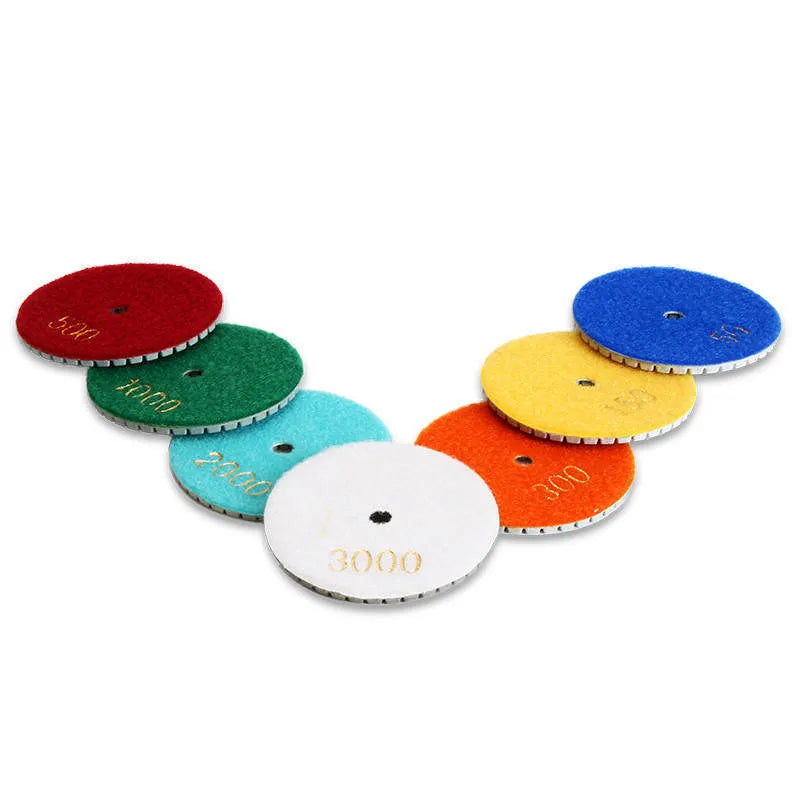 Set of 10 emery stone polishing discs with grits from 50 to 3000 mesh on a grey background.