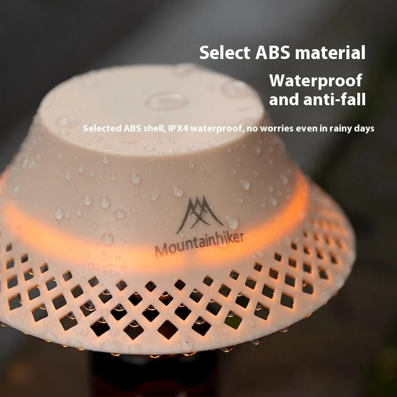 Beige rechargeable camping lantern with a wine bottle-shaped shade showing its USB-C port and gear switch.