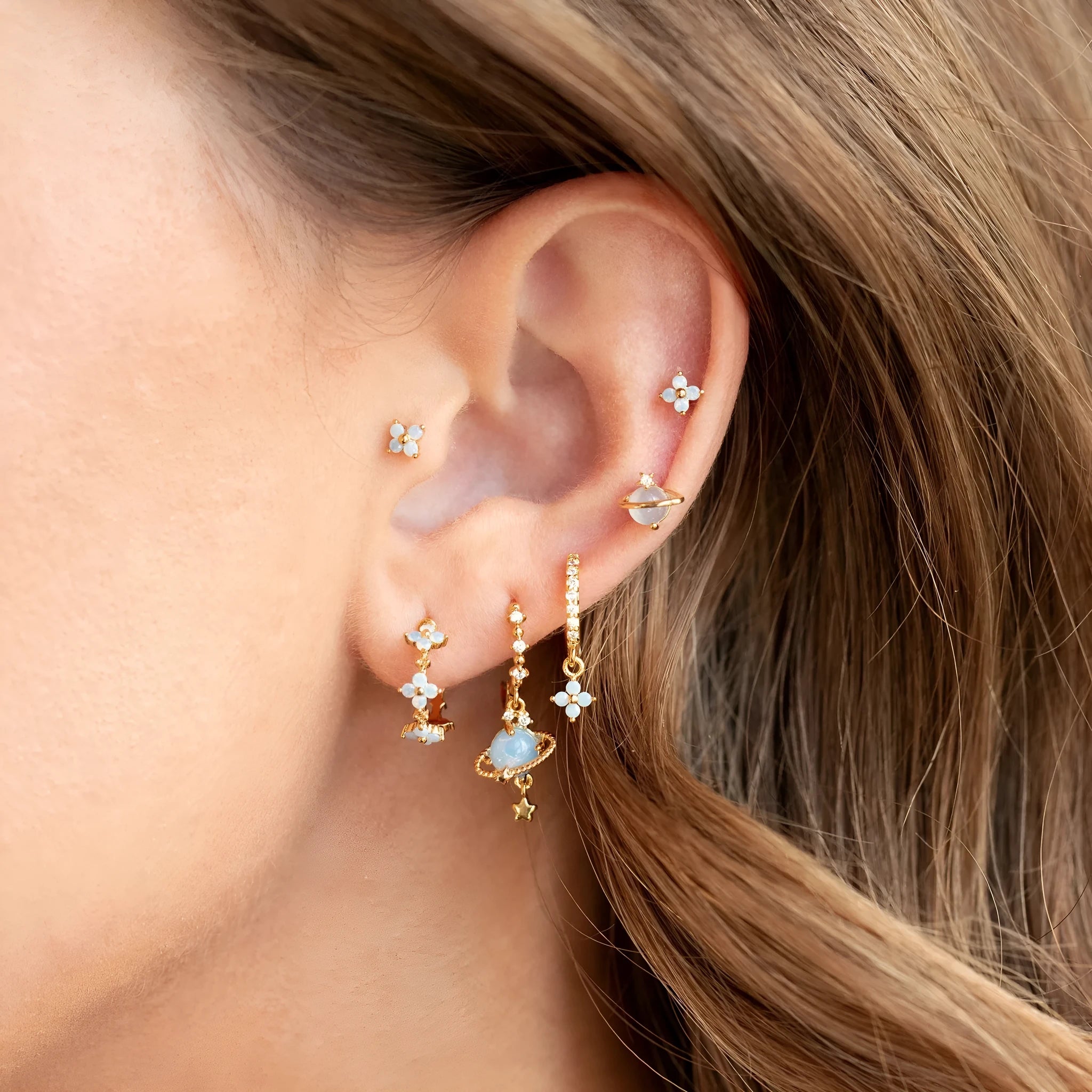 Gold and silver flower shaped stud earrings with a central zircon stone, showing front and back.